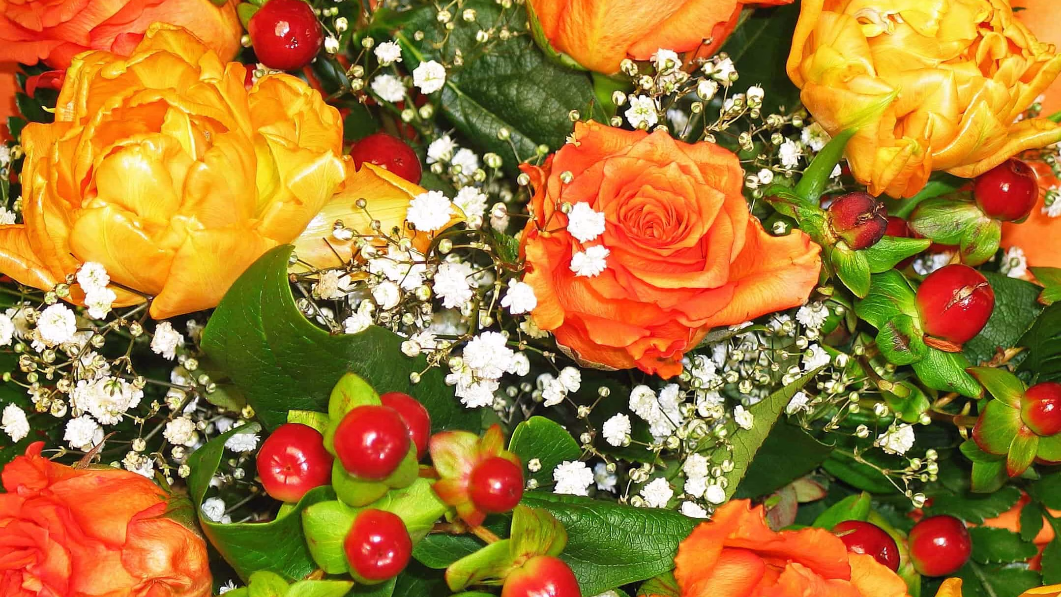 A floral arrangement of orange, yellow and white flowers