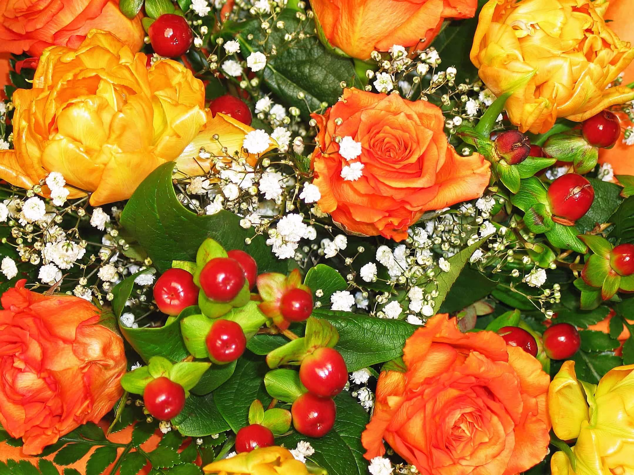 A floral arrangement of orange, yellow and white flowers
